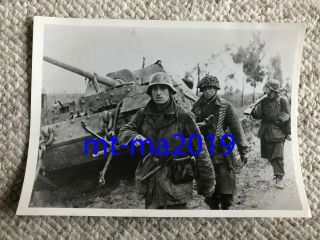 Ww2 Press Photograph - German Combat Troops March Past A Knocked Out Tank 1944