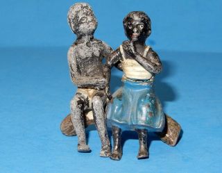 Old Lead Figure Of A Black Boy Comforting A Girl Sitting On A Log
