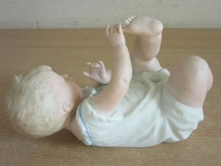 Antique German Heubach porcelain figurine baby boy on his back 7.  5 