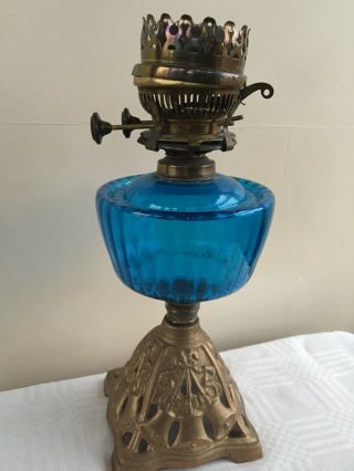 A Cast Iron Base Oil Lamp With Blue Glass Reservoir