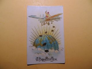 A Happy Year Vintage Embossed Postcard Plane Flying Over Earth With Coins