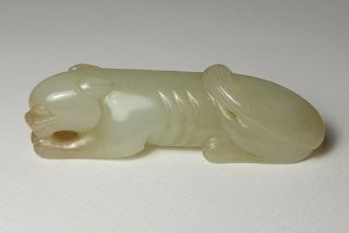 A Fine Qing Dynasty Pale Celadon Jade Carved As A Recumbent Tiger.