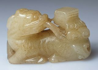 A Fine Qing Dynasty Pale Celadon Jade Carved As A Recumbent Qilin.