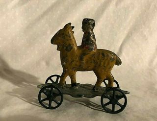 Early American Tin Toy Penny Type Toy Boy On Goat