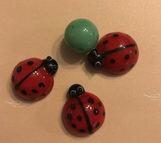 Three Glass Ladybugs With The Small Green Glass Ball
