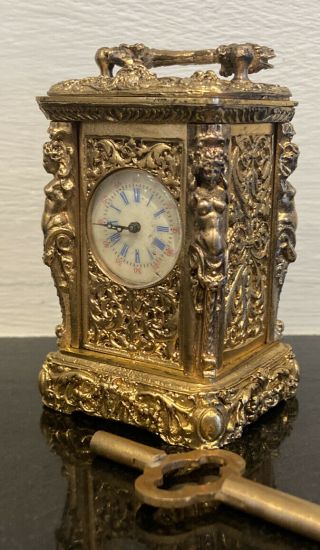 a gilt figural miniature carriage clock with circular enamel dial 2